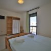 Una camera da letto con letto matrimoniale, finestra, armadio e TV a parete.