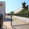 Ingresso con cancello nero e cartello della reception 