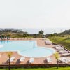 Piscina esterna con lettini, prato curato e vista panoramica.