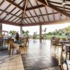 Una sala ristorante esterna con tavoli apparecchiati vista giardino.