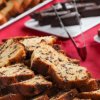Fette di plumcake ai pezzi di cioccolato su tovaglia rossa.