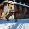 Rustico in pietra e legno con neve e cielo limpido.