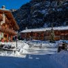Vista di chalets innevati con montagna sullo sfondo.