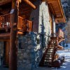 Dettaglio di una casa in legno e pietra con scale esterne.