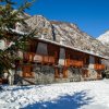 Chalet in pietra in montagna innevata.