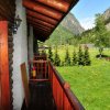 Balcone in legno con vista su prati e montagne.