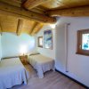 Due letti singoli affiancati in camera con tetto in legno.