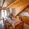 Cucina con tavolo da pranzo coperto e fiori.