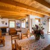 Soggiorno luminoso con travi in ​​legno e tavolo fiorito.