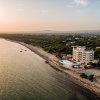 Spiaggia al tramonto con hotel e piscina sulla costa.