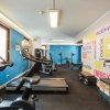 Palestra moderna con attrezzature e parete colorata.