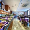 Ristorante con buffet ricco e tavoli apparecchiati con tovaglie viola.
