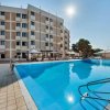 Piscina all'aperto davanti a un edificio a più piani sotto il sole.