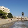 Una spiaggia con alcune persone e un grande edificio sullo sfondo.