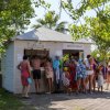 Persone in costume da bagno attorno a un chiosco sulla spiaggia.
