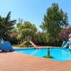 Piccola piscina con scivoli colorati e decorazioni a forma di animali per bambini.