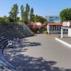 Un anfiteatro all'aperto con sedili in metallo e palco.