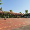 Ragazzi giocano a calcio su un campo all'aperto circondato da alberi fioriti.