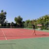 Due persone giocano a tennis all'aperto.