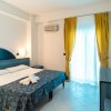 Stanza d'albergo con letto matrimoniale, tenda gialla e arredi blu.