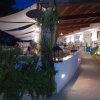 Un ristorante all'aperto di sera, con luci soffuse e piante decorative.