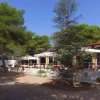 Un ristorante all'aperto circondato da alberi e ombrelloni bianchi.