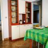 Interno di una cucina con tavolo apparecchiato e mobili.