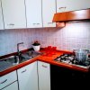 Cucina moderna con piano cottura, lavandino e decorazioni rosse.