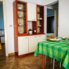 Sala da pranzo con credenza, tavolo apparecchiato e tovaglia verde.