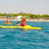 Persone in kayak gialli su mare azzurro.
