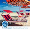 Sdraio e ombrelloni a righe rosse e blu su una spiaggia, testo promozionale.