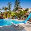Piscina con scivolo e palme attorno.