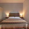 Camera da letto con letto matrimoniale e armadio bianco.