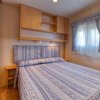 Camera con letto matrimoniale, testiera imbottita e tende abbinate.