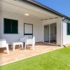 Veranda con sedie bianche e prato verde.