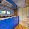 Cucina blu con fornelli e tavolo con frutta.