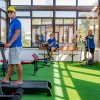 Persone in palestra usano tapis roulant e cyclette.