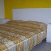 Camera con letto matrimoniale e testiera bianca.