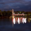 Fontana illuminata su lago di notte.