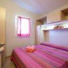 Camera da letto con letto matrimoniale rosa.