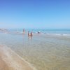 Spiaggia con persone che giocano sull'acqua bassa.