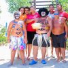 Gruppo di persone in costume su una spiaggia sotto il sole.