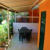 Patio coperto con tavolo e sedie, parete arancione.