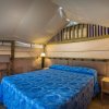 Interno di una tenda con letto matrimoniale e illuminazione soffusa.