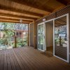 Veranda in legno con porte scorrevoli e tetto coperto.