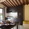 Cucina moderna con tavolo apparecchiato, letto singolo e soffitto in legno.