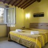 Camera con letto matrimoniale, copriletto giallo, finestra aperta.