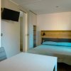 Camera semplice con letto matrimoniale, tavolo bianco e TV a schermo piatto.