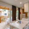 Interno di un appartamento con tavolo da pranzo bianco, cucina e terrazza esterna.