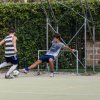 Tre ragazzi giocano a calcio su un campo all'aperto.